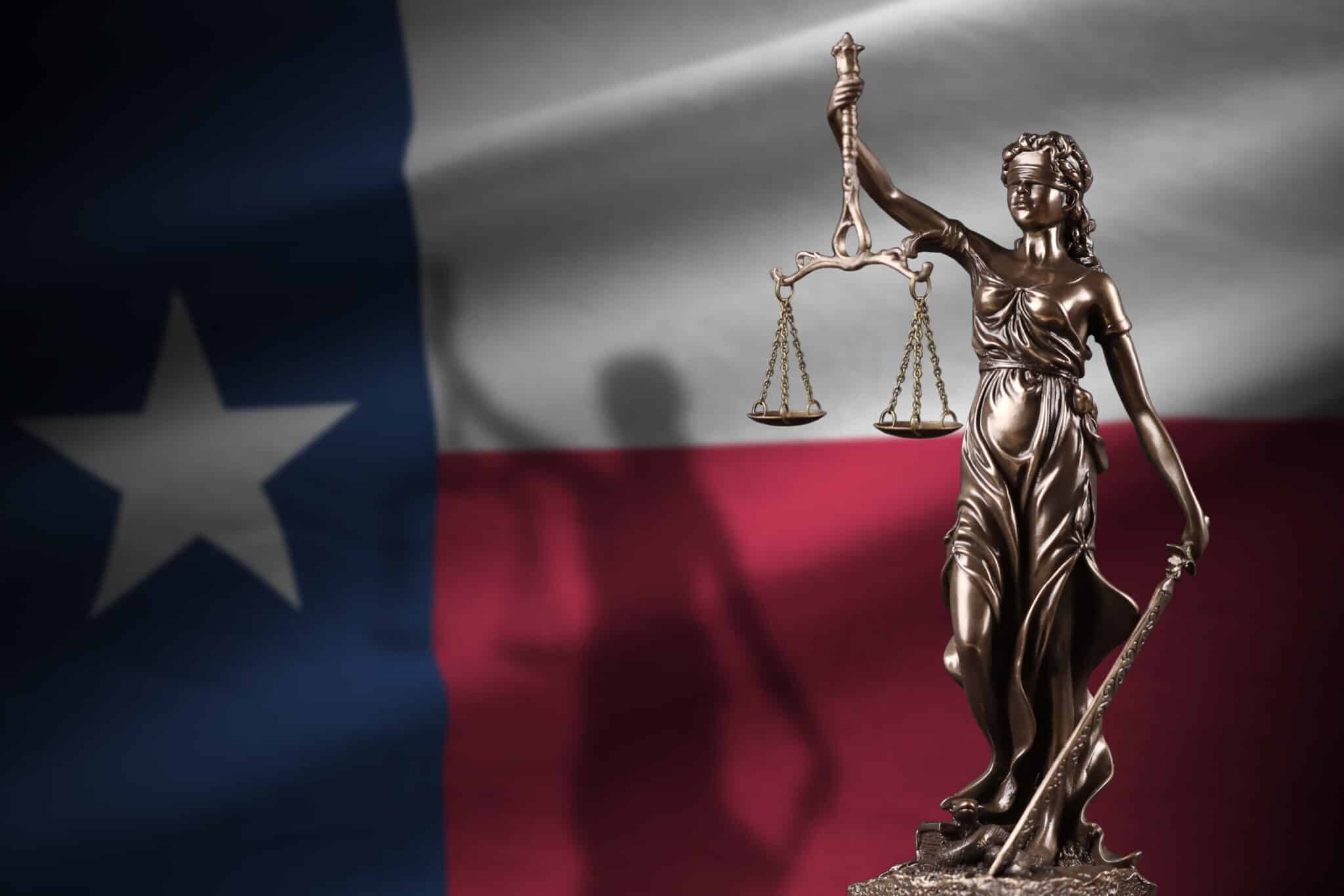 Texas US state flag with statue of lady justice and judicial scales in dark room. Concept of judgement and punishment