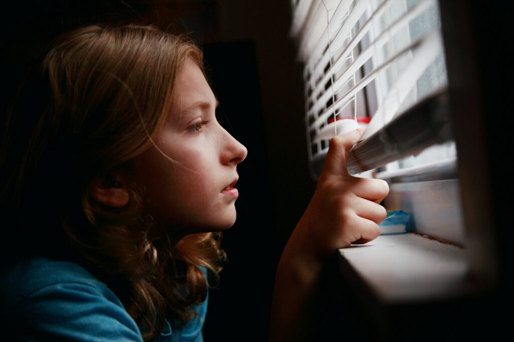 girl looking through a window