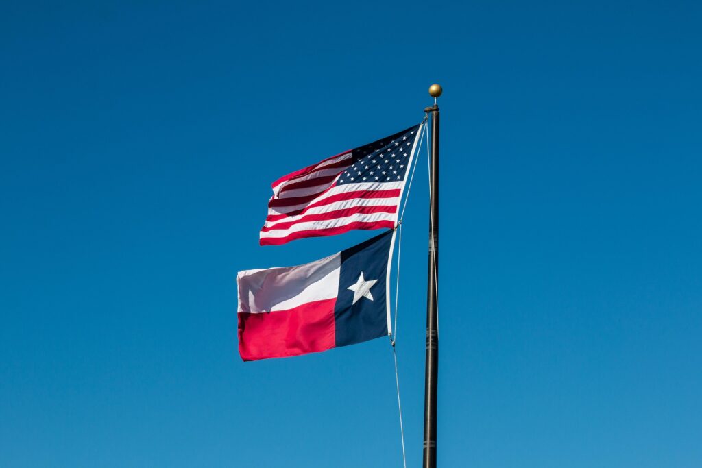 US and Texas flags on a pole
