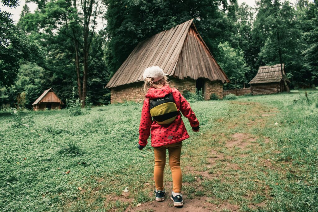 girl walking towards a hut