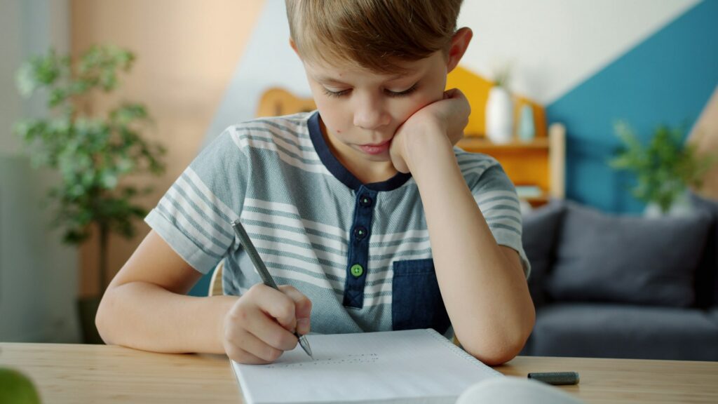 child writing on a paper