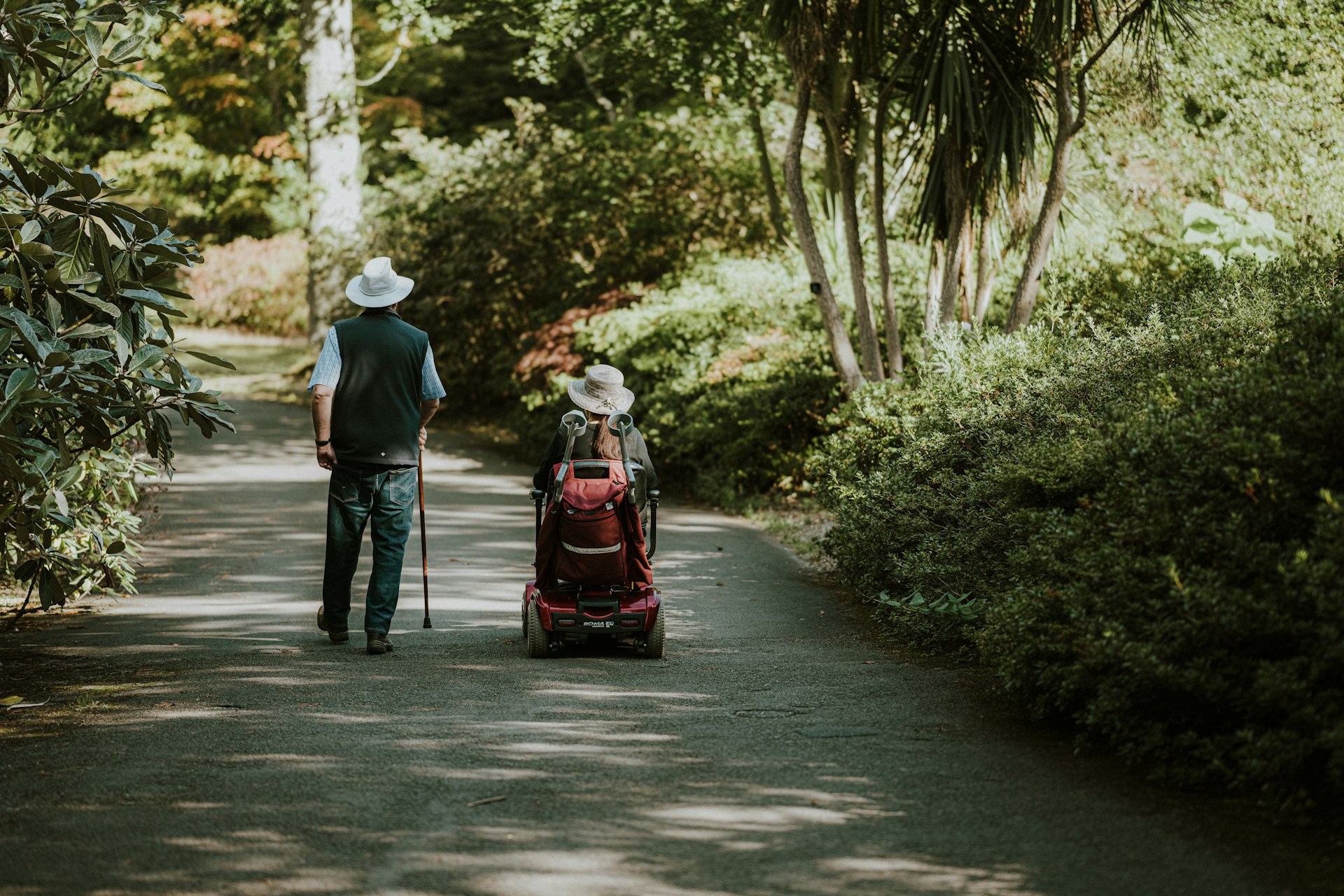 a person walking with a cane and another on a wheelchair